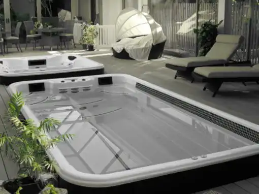 Spa de nage blanc et noir sur terrasse avec espace détente